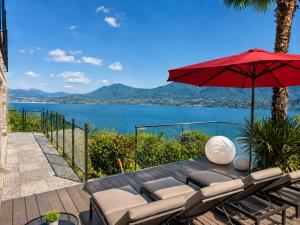 a patio with a table with chairs and an umbrella at Villa Spa Chiara Luna by Lago Reisen in Oggebio