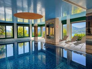 a house with a pool with chairs and windows at Villa Spa Chiara Luna by Lago Reisen in Oggebio
