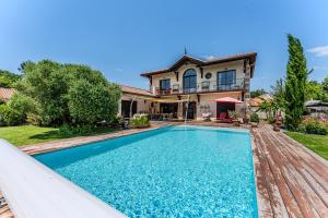 a house with a swimming pool in front of a house at Tomland in Parentis-en-Born