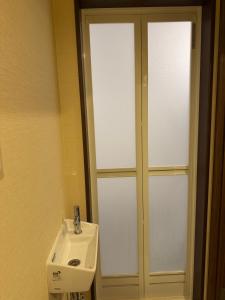 a bathroom with a white sink and a mirror at WUMETEI Japanese-style lodge in Kyoto