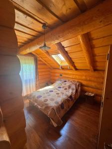 a bedroom in a log cabin with a bed at Cabana Bocus in Păltinoasa