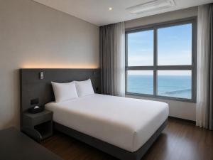 a bedroom with a large white bed and a large window at Sky Stay in Incheon
