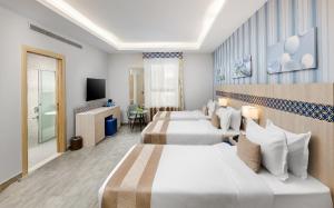 a hotel room with two beds and a television at Durrat Balensia Hotel - فندق درة بلنسية in Medina