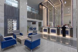 a lobby with blue chairs and a table and a counter at Durrat Balensia Hotel - فندق درة بلنسية in Medina