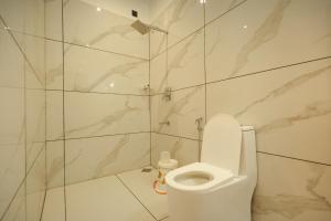 a bathroom with a toilet and a marble wall at Rivendell resort Munnar in Munnar