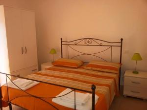 ein Schlafzimmer mit einem Bett mit einer orangefarbenen Tagesdecke in der Unterkunft Appartamento Aurora in Praia a Mare