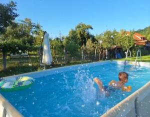 a young boy is in a swimming pool at Ograda Bunicilor Sarata in Sărata
