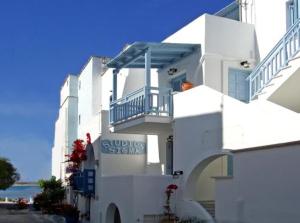 a white building with a sign on the side of it at Sigma Studios on The Beach in Naxos Chora