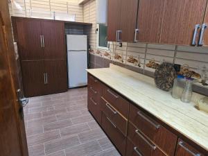 a kitchen with wooden cabinets and a white refrigerator at La Casa de Larache in Larache