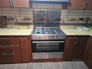 a kitchen with a stove and wooden cabinets at La Casa de Larache in Larache
