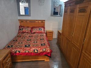 a bedroom with a bed with a red comforter at La Casa de Larache in Larache