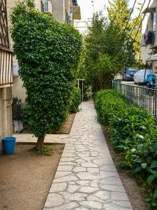 a leafy green bush next to a sidewalk at Urban Waves 1 in Netanya