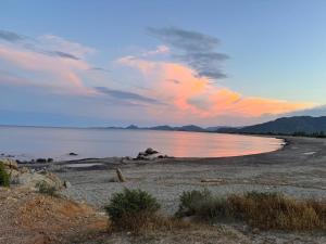a beach with a cloudy sky and the water at Luna e Sentidu in Villaputzu