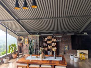 a living room with a table and a tv at Moonlight Chillers By LexStays in Yedapalli