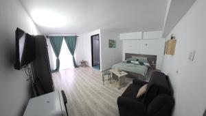 a living room with a bed and a couch at Pensiunea Glasul Pădurii in Moieciu de Jos