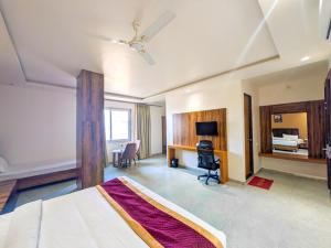 a hotel room with a bed and a desk and a room at Hotel Aashiyana in Shahdol