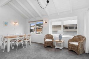 a dining room with a table and chairs at Beachfront Marine Parade in Mount Maunganui