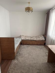 a small bedroom with a bed and a chandelier at Дом in Bishkek