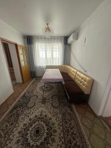 a room with a couch and a table on a rug at Дом in Bishkek