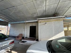 a house with a garage with a car parked at Дом in Bishkek