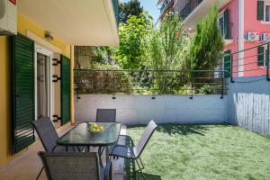 a patio with a table and chairs and a yard at Althaia Three-Bedroom Maisonette by Konnect in Corfu