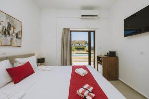 a bedroom with a bed with a red towel on it at Casa Di Notos Beach Hotel - Georgioupolis in Georgioupolis +45 photos