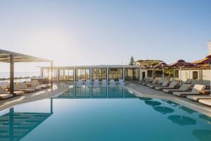 a swimming pool with lounge chairs and a resort at Casa Di Notos Beach Hotel - Georgioupolis in Georgioupolis
