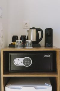 a microwave on a shelf with a coffee maker and a coffee pot at Casa Di Notos Beach Hotel - Georgioupolis in Georgioupolis