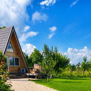 a tiny house with a trailer in the yard at A Frame YRA cu ciubar in Câmpulung