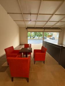 a living room with red chairs and a table at Fatses in Nea Plagia