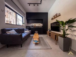 a living room with a couch and a tv at Urban Waves 1 in Netanya
