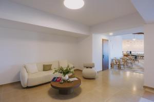 a living room with a couch and a table at Casa Di Notos Beach Hotel - Georgioupolis in Georgioupolis