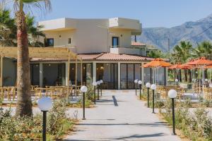 a resort with tables and chairs and umbrellas at Casa Di Notos Beach Hotel - Georgioupolis in Georgioupolis