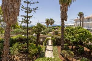 a garden with palm trees and a pathway at Villa Preside in Noto Marina