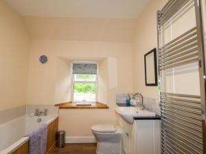 a bathroom with a sink toilet and a window at Laundry Cottage in Strathpeffer +15 photos