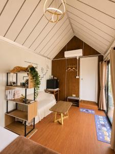 a bedroom with a bed and a table in a room at NearBKKHomestayAirport in Bang Phli