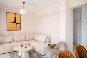 a living room with a white couch and chairs at Althaia Three-Bedroom Maisonette by Konnect in Corfu +67 photos