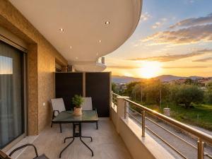 a balcony with a table and a sunset at Danita Apartments in Paleros