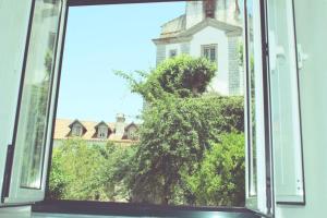 a window with a view of a tree in front of a building at Sintra1012 Boutique Guesthouse in Sintra