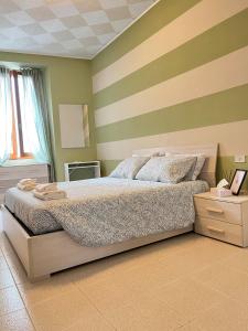 a bedroom with a bed and a striped wall at Ottanio 2 Lake Apartments in Pisogne