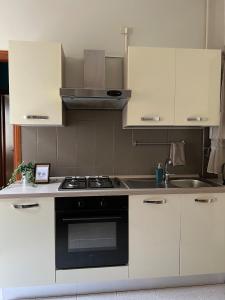a kitchen with white cabinets and a stove top oven at Ottanio 2 Lake Apartments in Pisogne +30 photos