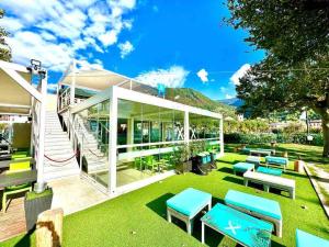 a patio with green grass and blue benches at Ottanio 2 Lake Apartments in Pisogne