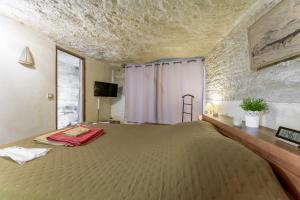 a bedroom with a large bed and a window at Studio Troglodyte en Provence in Cornillon-Confoux