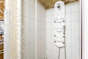 a shower in a bathroom with white tiles at Studio Troglodyte en Provence in Cornillon-Confoux +13 photos