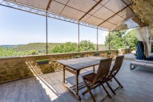 a table and chairs on a balcony with a view at Studio Troglodyte en Provence in Cornillon-Confoux