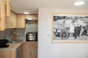 a kitchen with a picture of a family with a wagon on the wall at Christie's Home Meteora in Kalabaka +9 photos