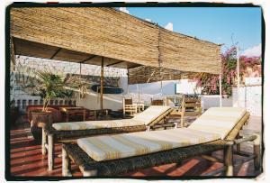 a group of benches with umbrellas on a deck at Dar Al-Andalus in Tamraght Ouzdar