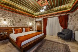 a bedroom with a king sized bed and a chair at Latona Stone Palace in Göreme