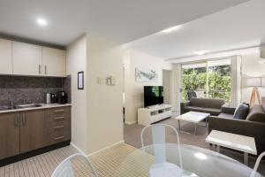 a kitchen and living room with a couch and a table at Solara at Aqua Mantra in Nelson Bay