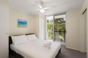 a bedroom with a white bed and a large window at Solara at Aqua Mantra in Nelson Bay +5 photos